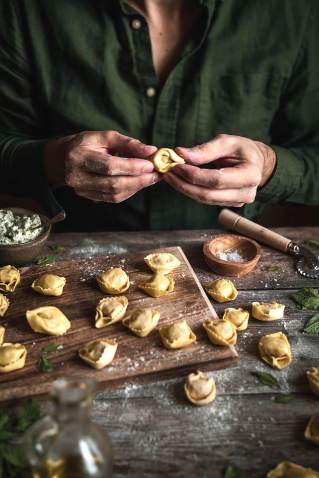 Manos formando tortellini frescos