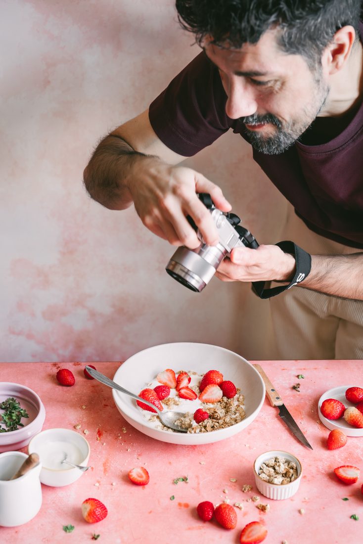 Marcos Tuero fotografiando un cuenco de yogur con fresas y granola