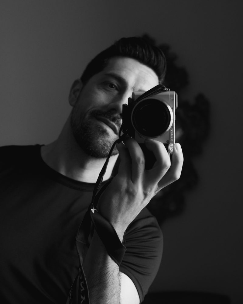 Marcos Tuero fotografiándose frente al espejo con su cámara, en blanco y negro