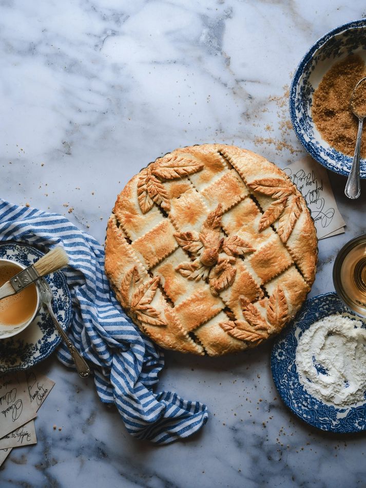 Pastel de hojaldre con hojas decorativas sobre azul